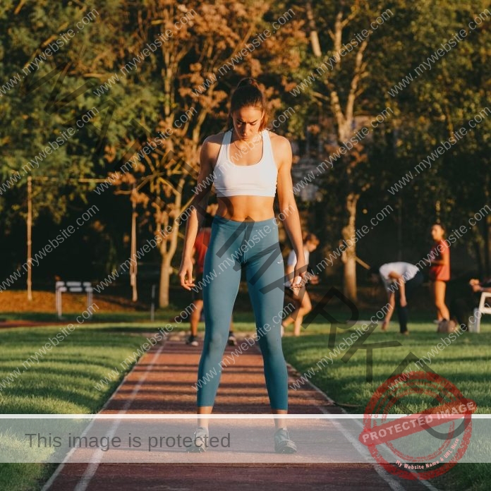 Sara Chiaratti standing in a sports bra and long tights, on a pathway, focused on training.