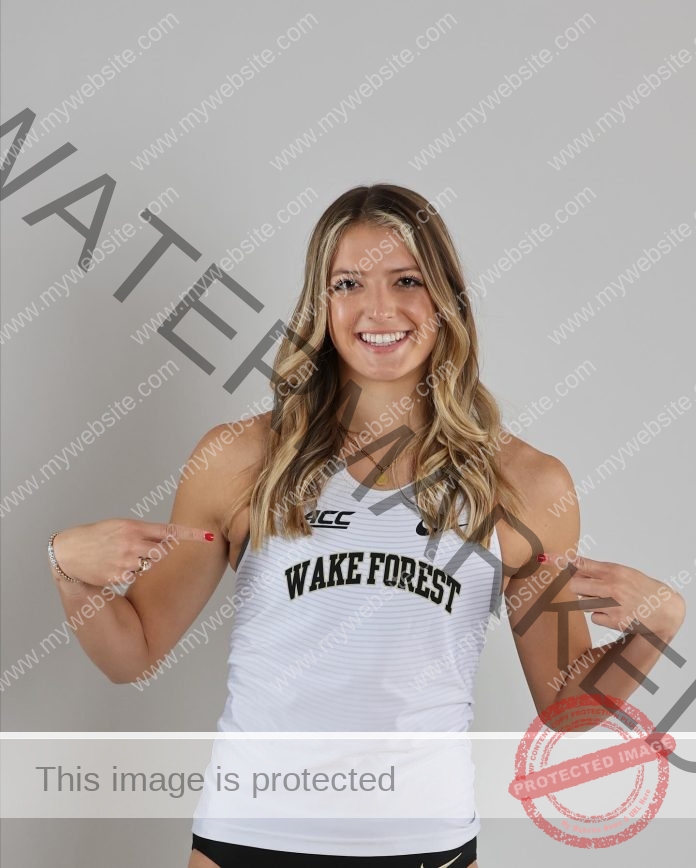 Addison Berry smiling in a photo shoot, wearing her Wake Forest track outfit and smiling.