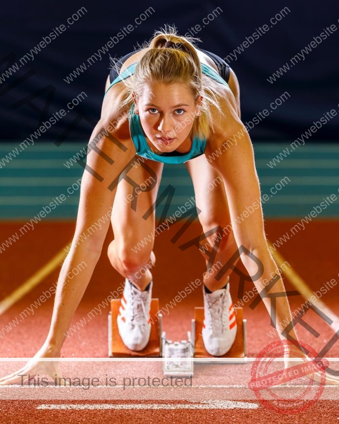 Sarah Lagger poses for media photos in the starting blocks