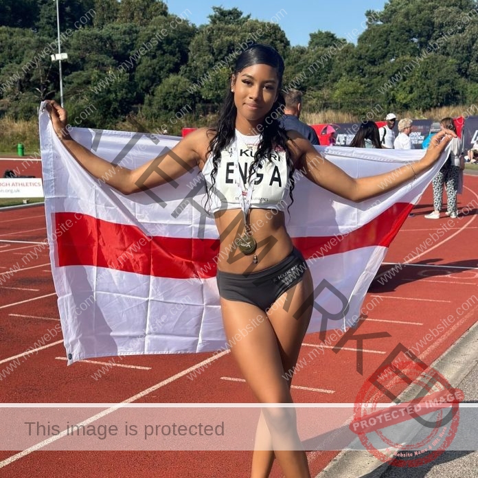 Delleah Bellgrave posing on the track with her flag