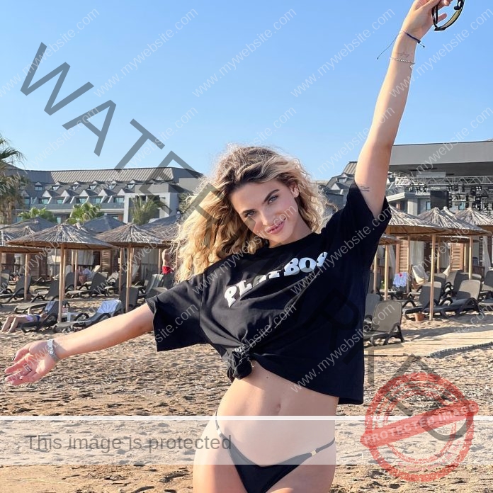 Violetta Razbeyko on the beach in a cropped Playboy t-shirt