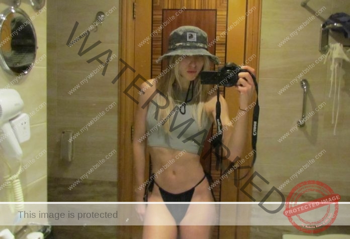 Yana Smagliy posing in a clingy top and bikini bottoms for a mirror selfie