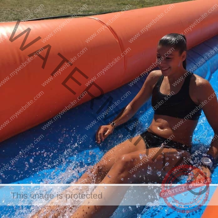 Aleksandra Nácheva in a bikini sliding down an inflatable water slide.