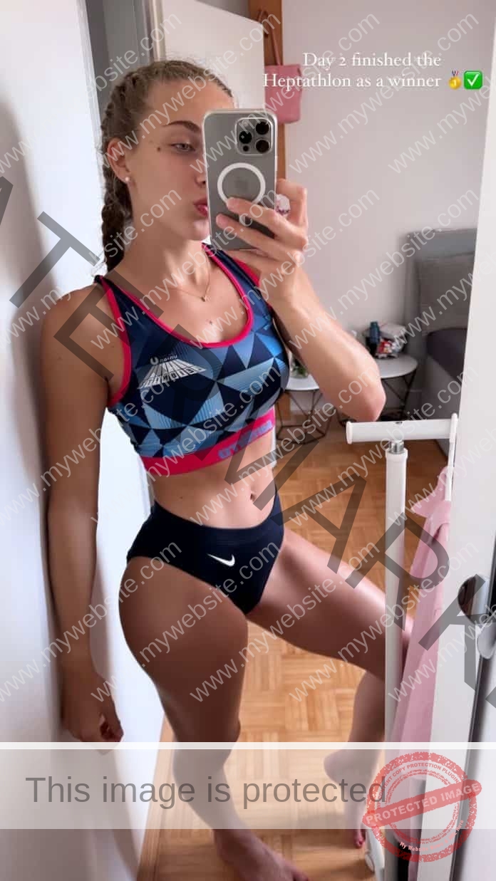 Noelle Puchinger poses in her track uniform for a bedroom selfie