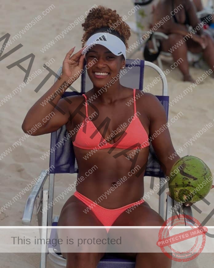 Lorraine Barbosa Martins relaxes on the beach in a peach/pink bikini?