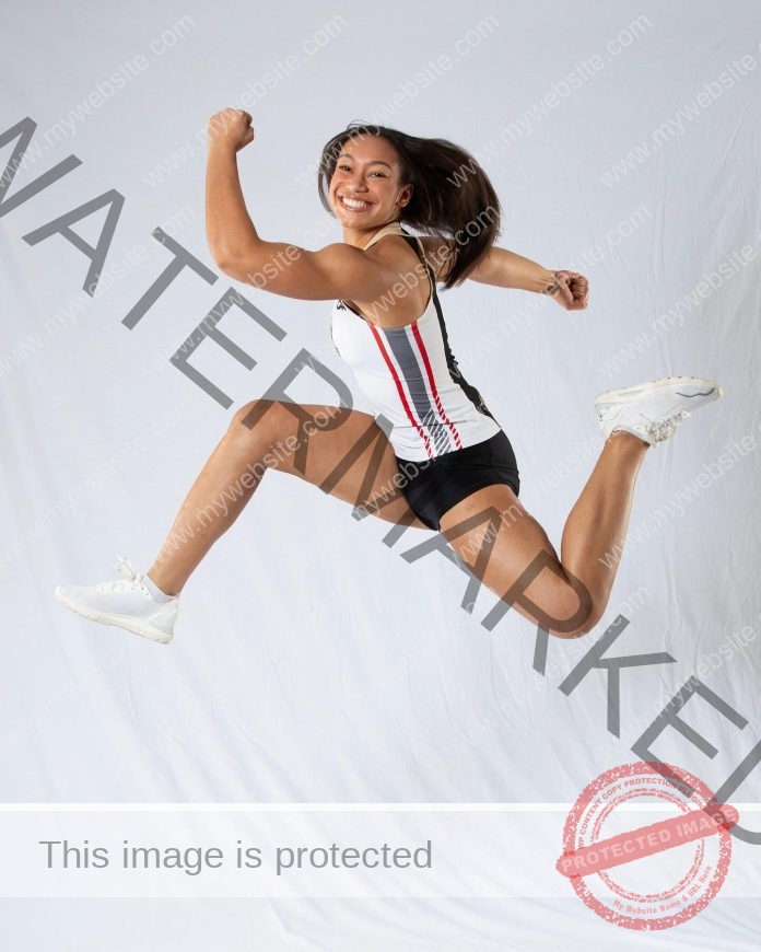 Annalisa Marckmann posing in mid-air in her track uniform for her media day photos.