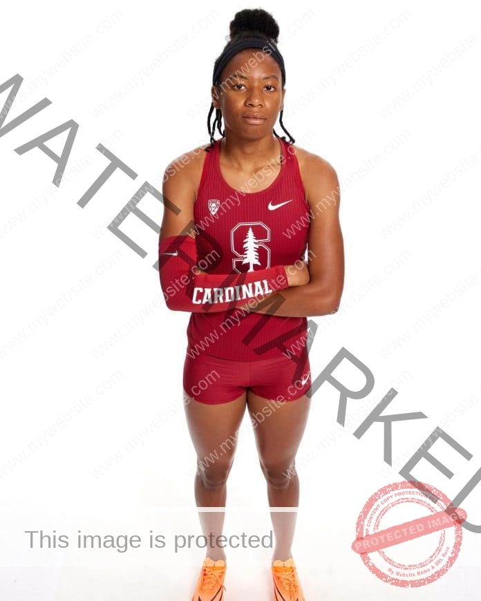 Alyssa Jones standing cross-armed for a photo shoot in her Stanford track attire, a white background in the back.