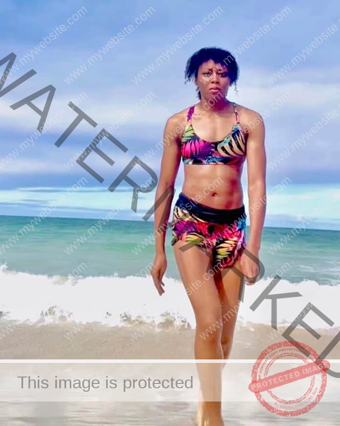 Ameia Wilson walking on the beach, wearing a patterned swimsuit