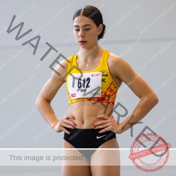 Claire Azzopardi concentrating before a foot race, wearing her track and field uniform and number 612