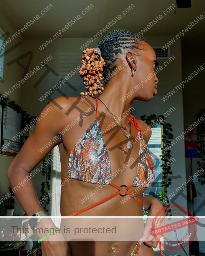 Anna Foreman wearing a floral print bikini top, looking away from the camera.