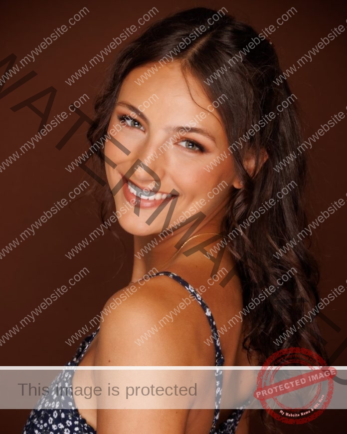 Elise Perrin posing for a professional headshot, shoulder showing and a big smile.