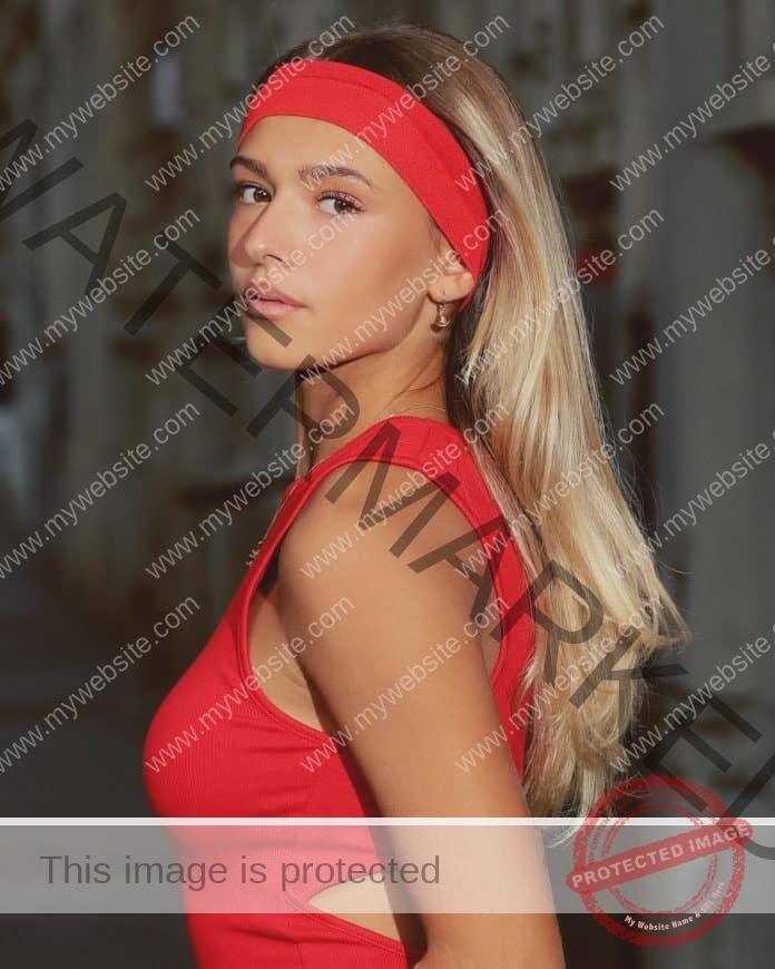 Erika Saraceni posing for a photo, wearing a red headband and red tank top.