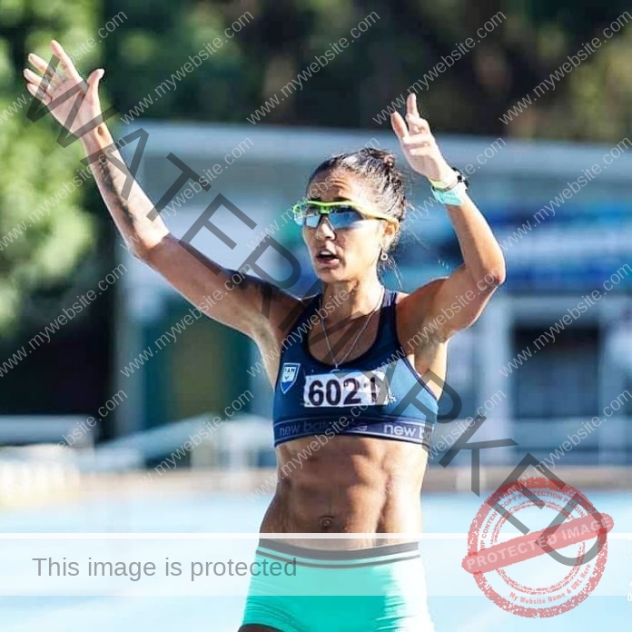 Lorena Sosa wearing her track uniform and finishing well in a race, gives us two thumbs up.