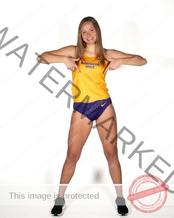 Katy Stephens posing for a photo shoot in her college track uniform, yellow shirt and purple shorts.