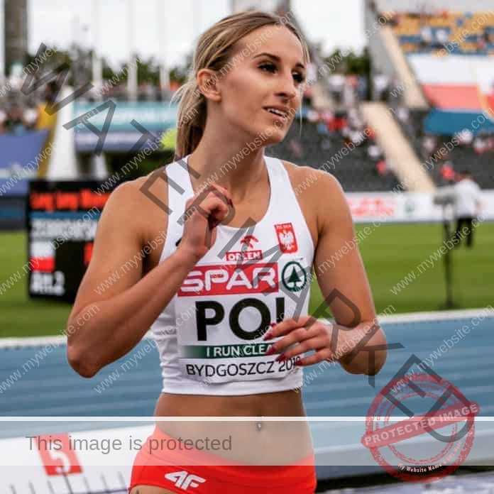 Magdalena Bokun smiling after a ace, wearing her Poland track outfit.