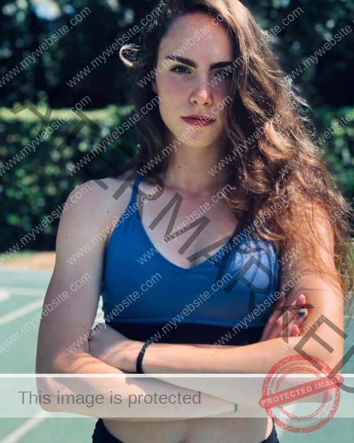 Vittoria Fontana standing in a blue sports bra, arms folded, looking at the camera.