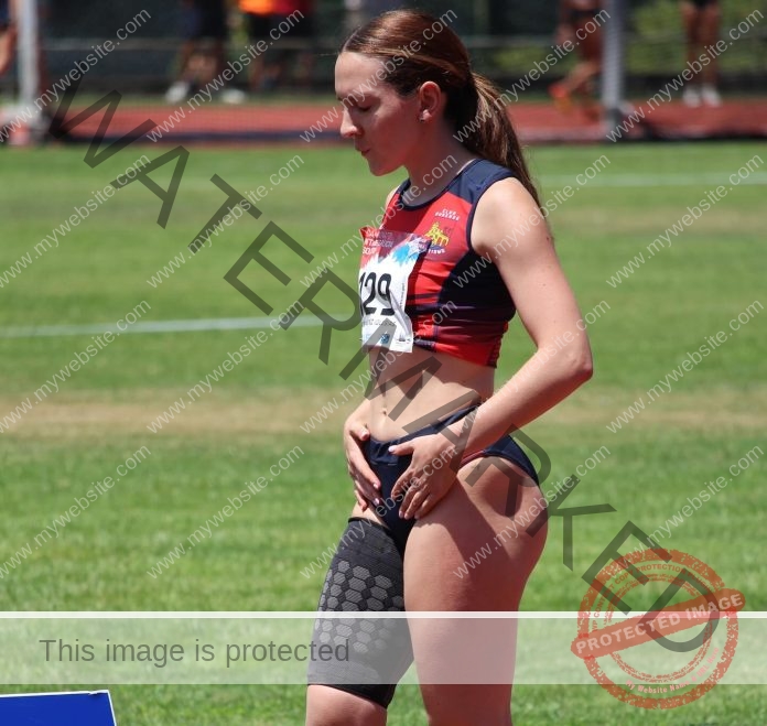 Alba Martinez flexing in athletic wear, displaying strong physique with raised arm pose.