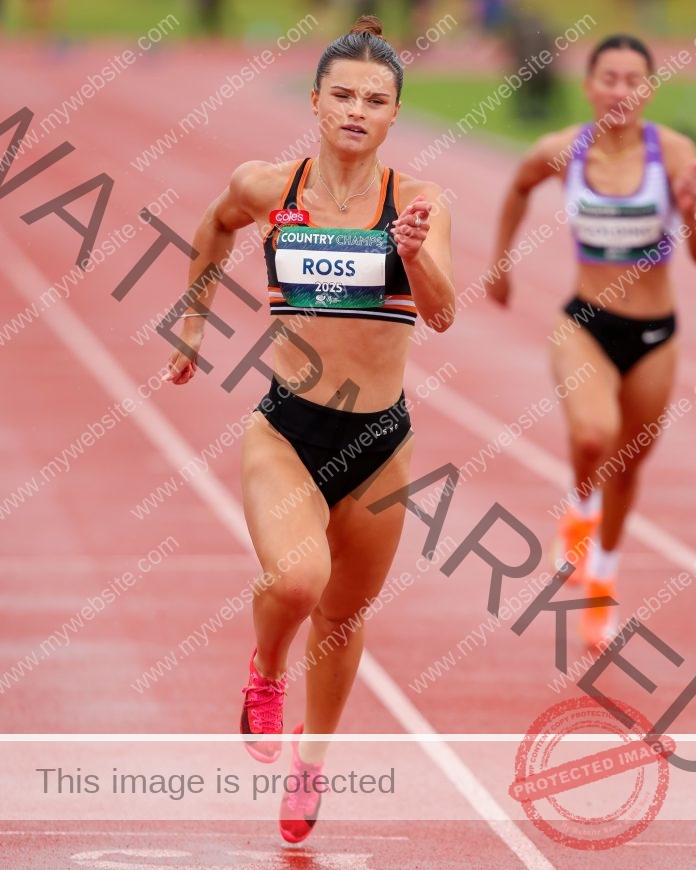 Ava Ross sprinting on a red track during a competitive outdoor race under cloudy skies.