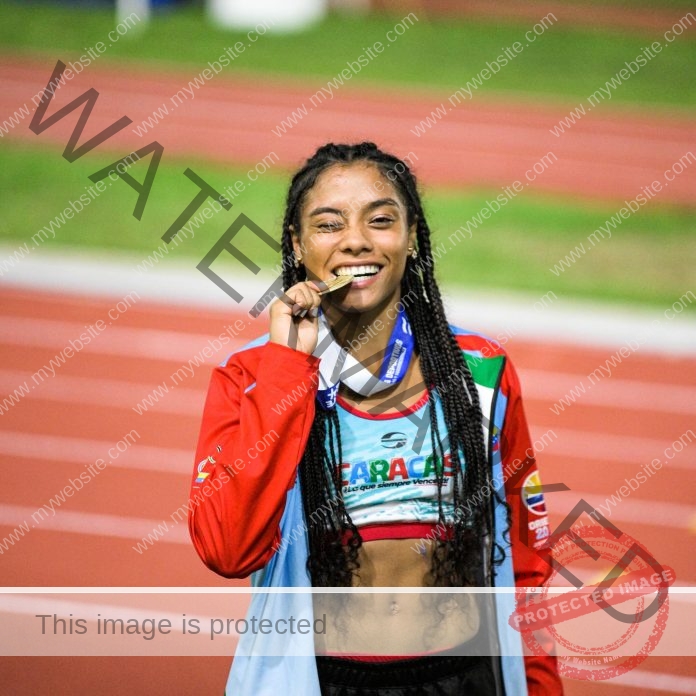 Eidymar Alejandra after winning a medal on the track, posing for a picture biting the medal.