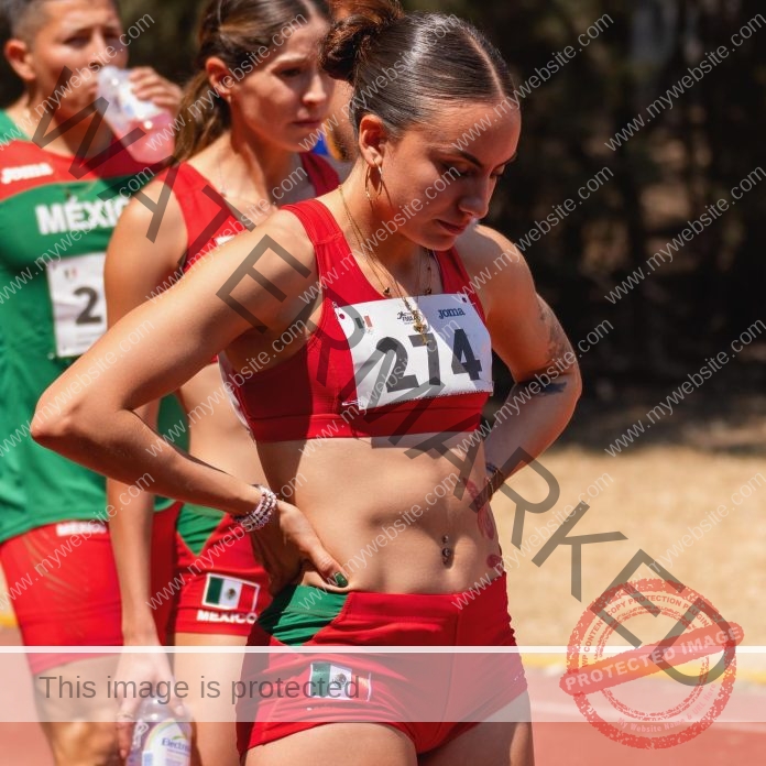 Sofía Pineda of Mexico stands on the track, ready for a race, wearing her red track uniform.