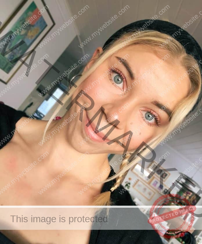 Taika Koilahti poses for a head shot with her beautiful blue eyes and a smile, black headband in her hair.