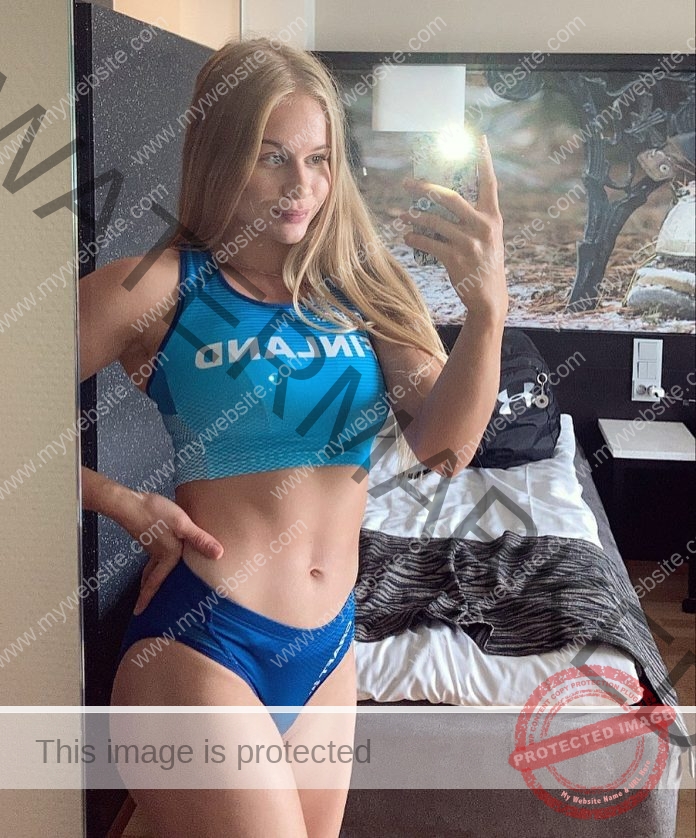 Saga Andersson taking a selfie in a mirror, wearing a blue crop top and blue bikini bottoms.