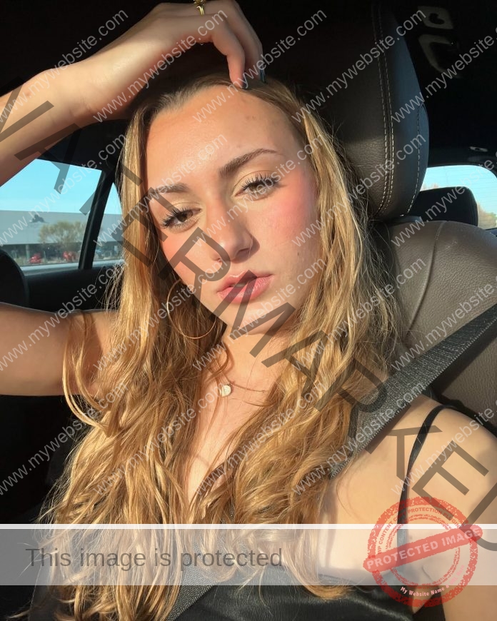 Aitana Alonso Simon sitting in a car taking a selfie, with a serious face, running her fingers through her hair.