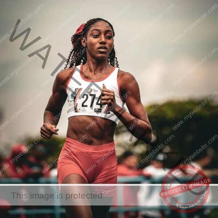 Paola Andrea Loboa exhales as she finishes a track and field event, in her uniform and number.