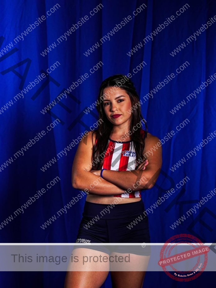 Jazmín Quiñonez posing confidently in red and white athletic wear against a dark blue backdrop.