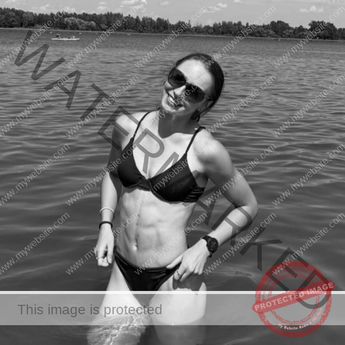 Klaudia Osipiuk enjoying a sunny day by the water in a black bikini.