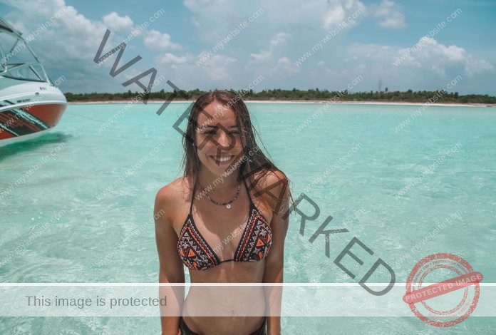 Macarena Borie Giralda standing in the ocean, with a big smile, wearing a patterned bikini.