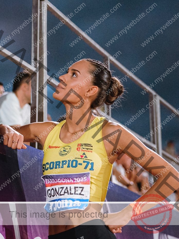 María González prepares with focus in yellow sportswear before competition amid cheering crowd.