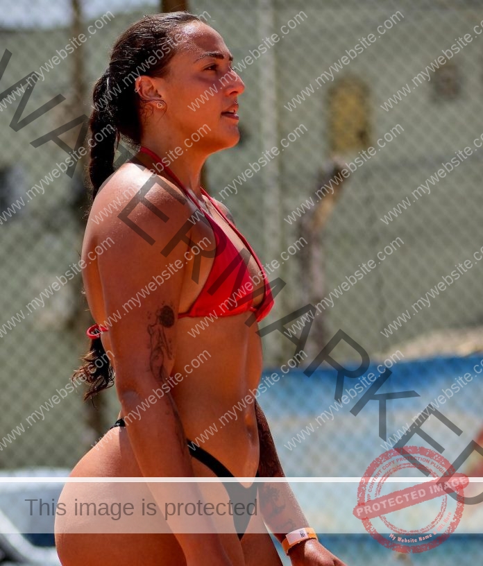 Sara M Prado posing outdoors in red bikini, showing athletic strength and confident summer style.
