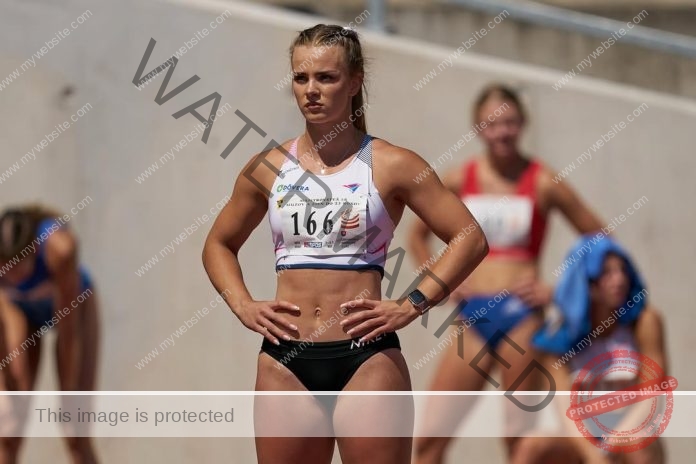 Tereza-Čorejová stand ready for a race, wearing her track uniform with number, black running tights.