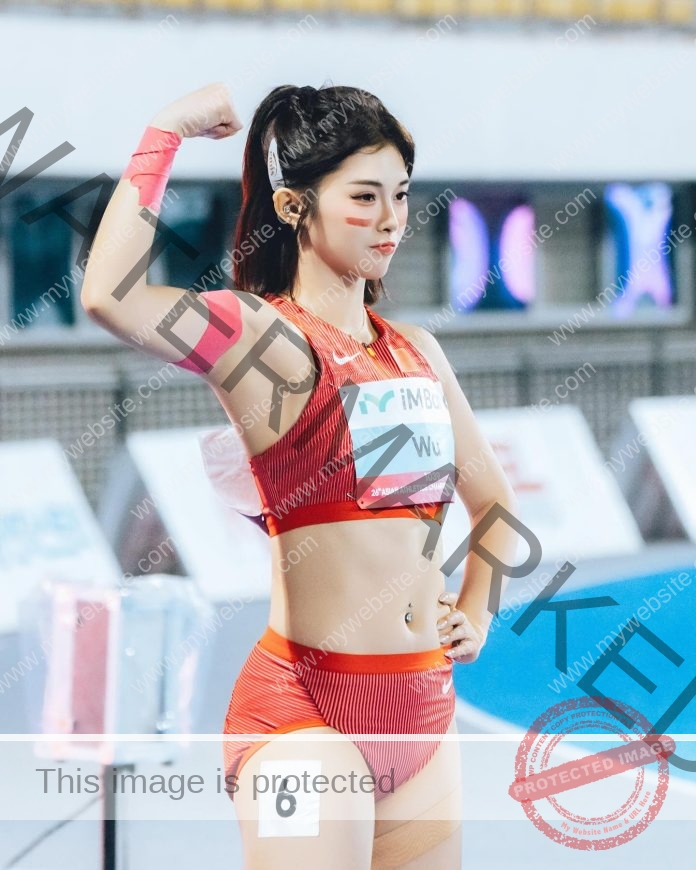 Chinese hurdler Wu Yanni flexes confidently at starting blocks in red China team uniform.