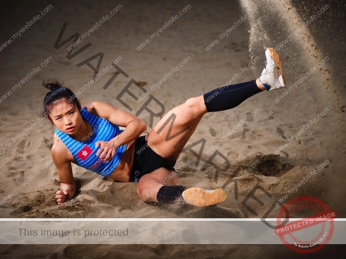 Hong Kongs Tiffany Yue Nga Yan dives dramatically for beach volleyball save, sand flying.
