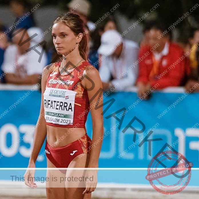 Celia Rifaterra preparing on the track in a red Spain uniform at a Jerusalem athletic event.