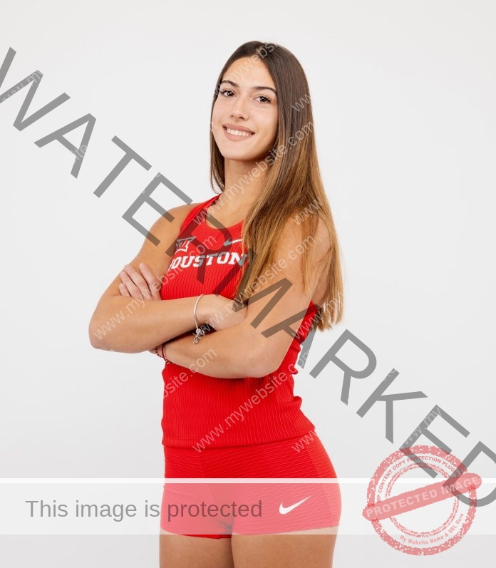 Evina Panagiotou posing in red Nike athletic uniform with arms crossed.