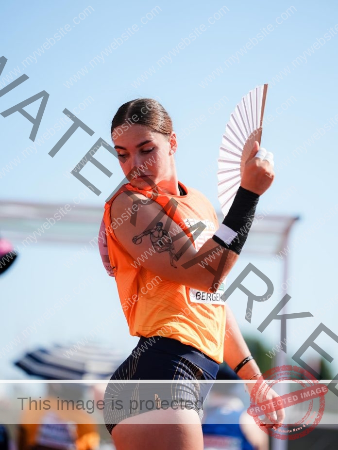 Ines Lopez preparing to throw with a fan-like implement at outdoor competition.