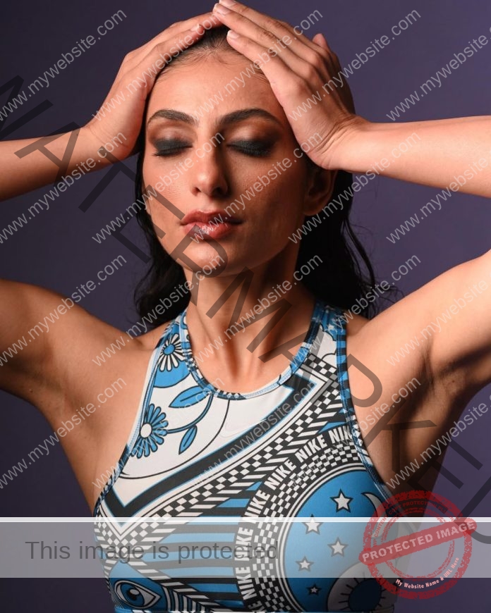 Niharika Vashisht poses gracefully in blue floral bodysuit against lavender background.