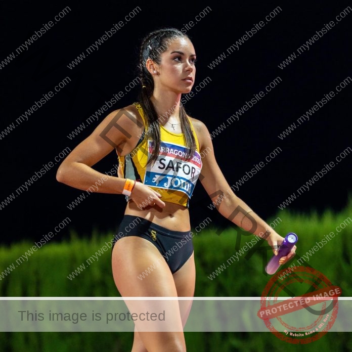 Paula Sierra competing in track and field event with baton in hand.