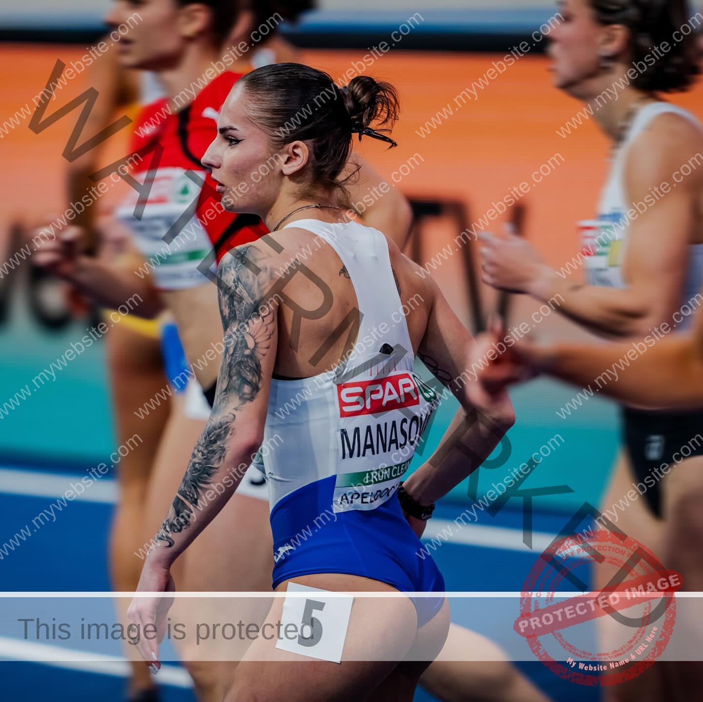 karolina-manasova-czechia-karolina_manasova-378 Karolína Maňasová, a female track athlete with an arm tattoo and number 5 on her shorts, stands among runners on an indoor track.