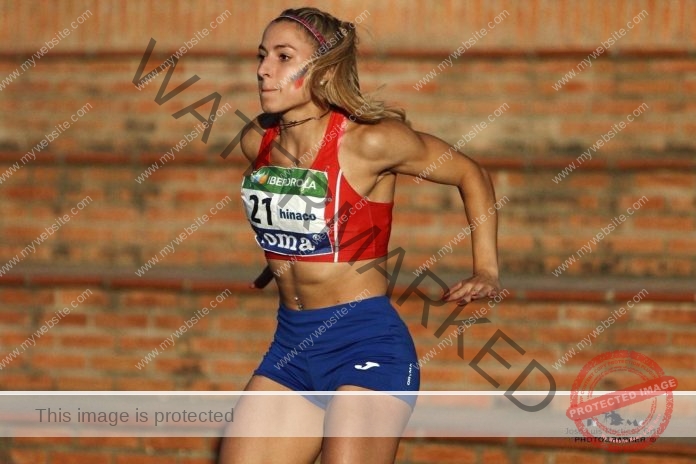 Mireya Oliver running in red tank top and blue shorts during competition in Spain.