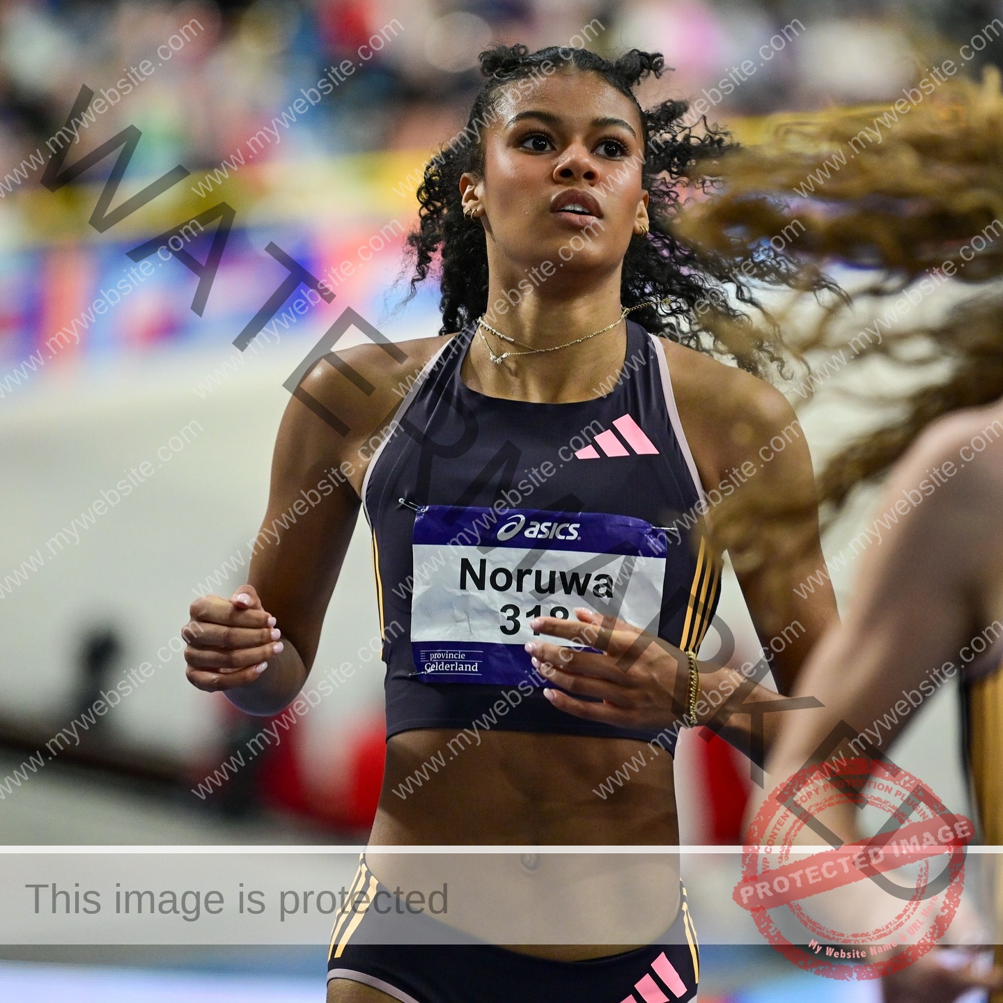 abigail-noruwa-netherlands-abigail_noruwa-u20-x-00073 Abigail Noruwa, track star from the Netherlands, competes in an indoor track event, focused and wearing a Noruw and Asics bib.