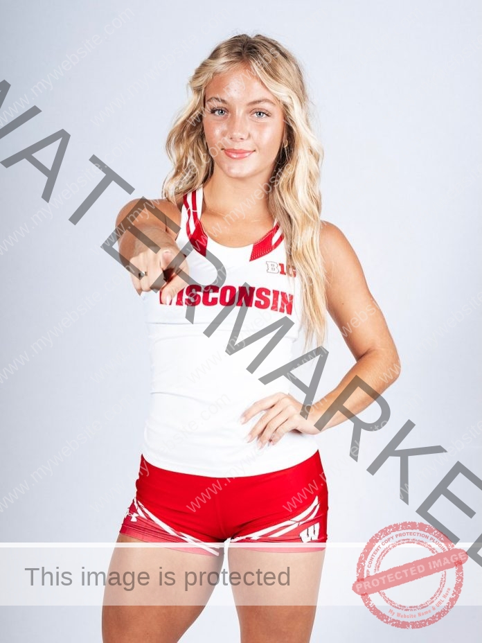 Addysan Prassas Addysan Prassas, a female track and field athlete, stands facing forward in a red and white Wisconsin uniform, pointing at the camera and resting her other hand on her hip against a plain background.