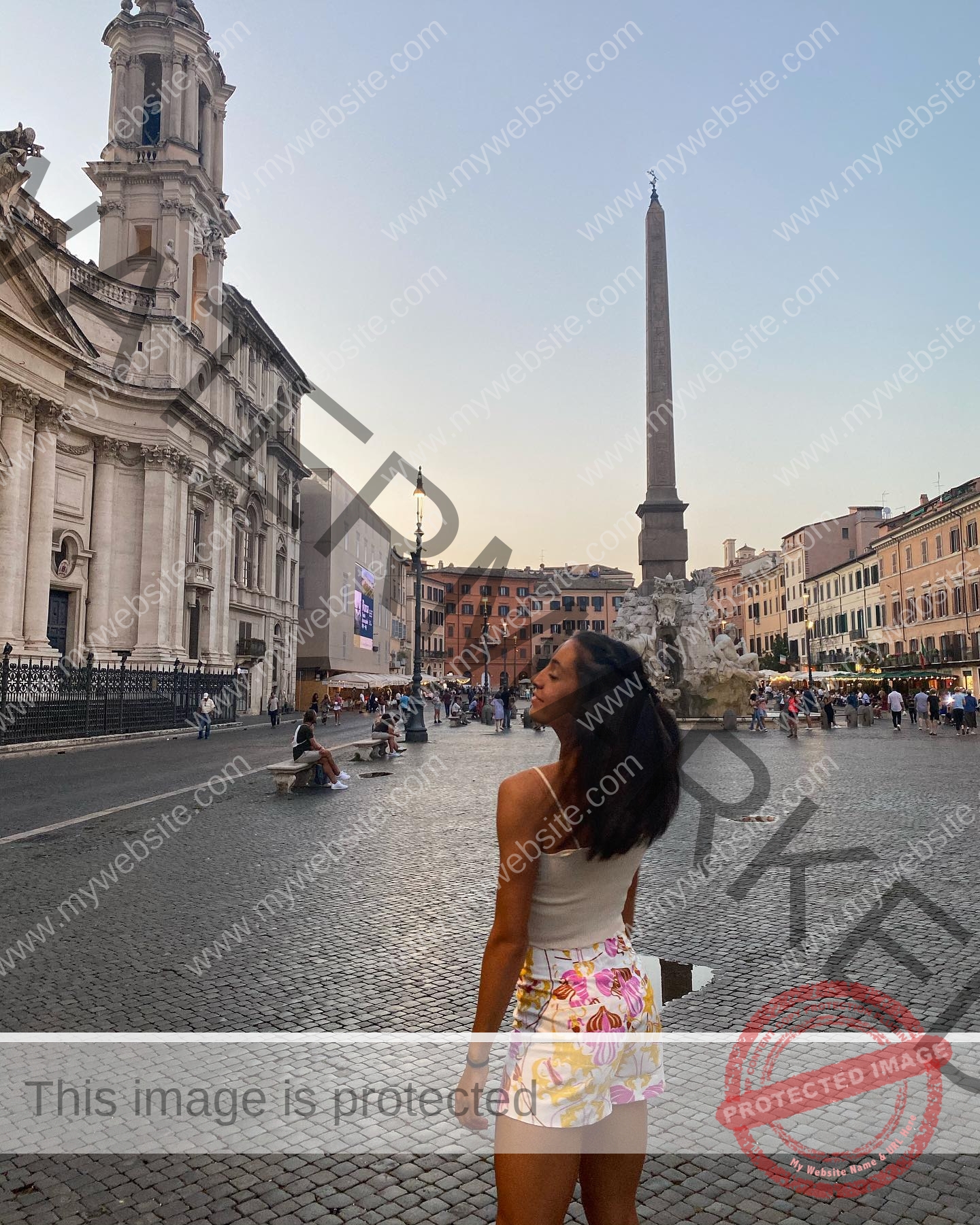 ainhoa-idoiaga-spain-ainhoidoiaga-00303 Ainhoa Idoiaga, track athlete from Spain, stands in a cobblestone square looking at an obelisk and historic buildings.