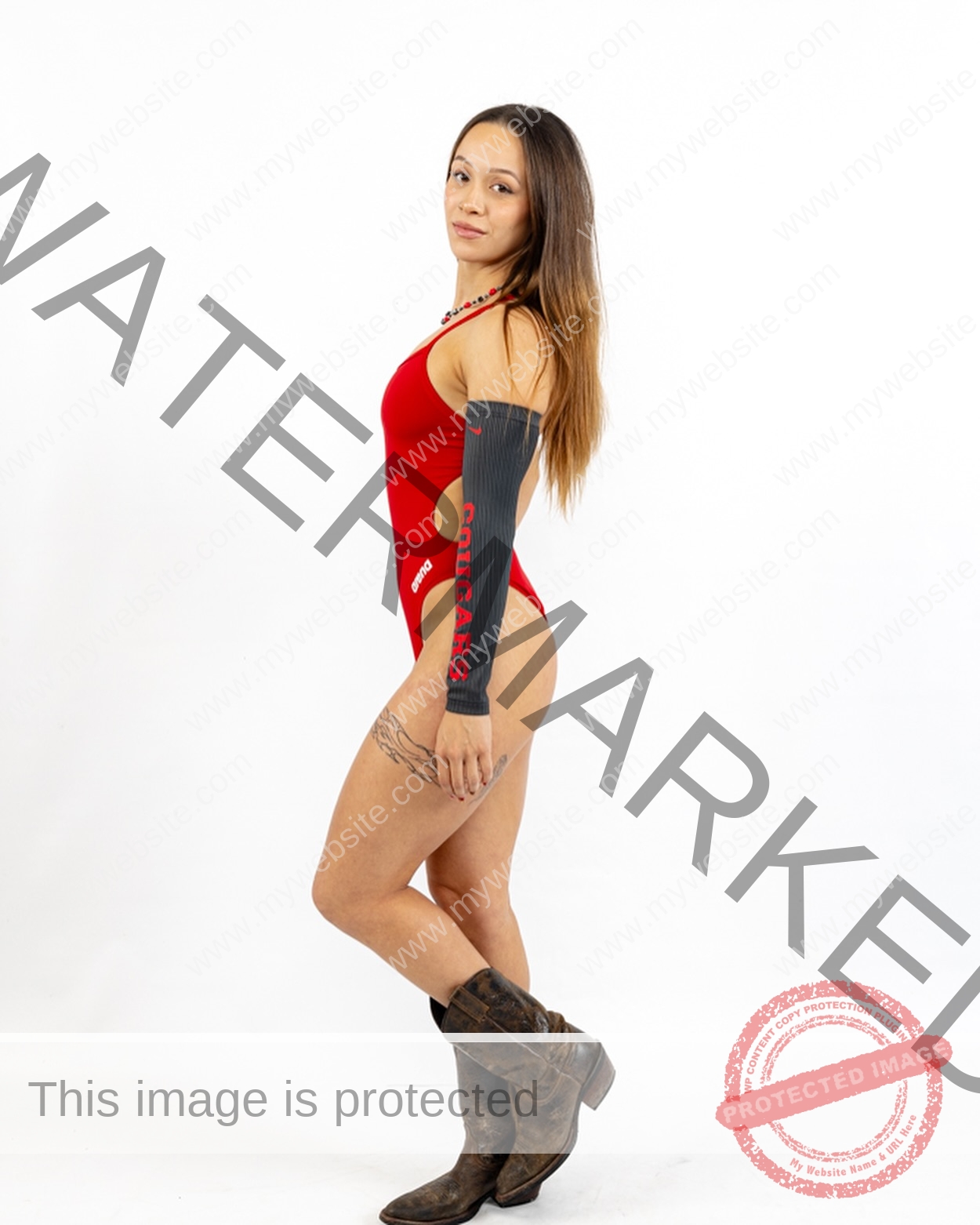 alondra-ortiz-costa-rica-alortizroman-663 Alondra Ortiz Alondra Ortiz, a swimming champion, stands sideways in a red swimsuit, COUGARS sleeves, and cowboy boots, looking confident.