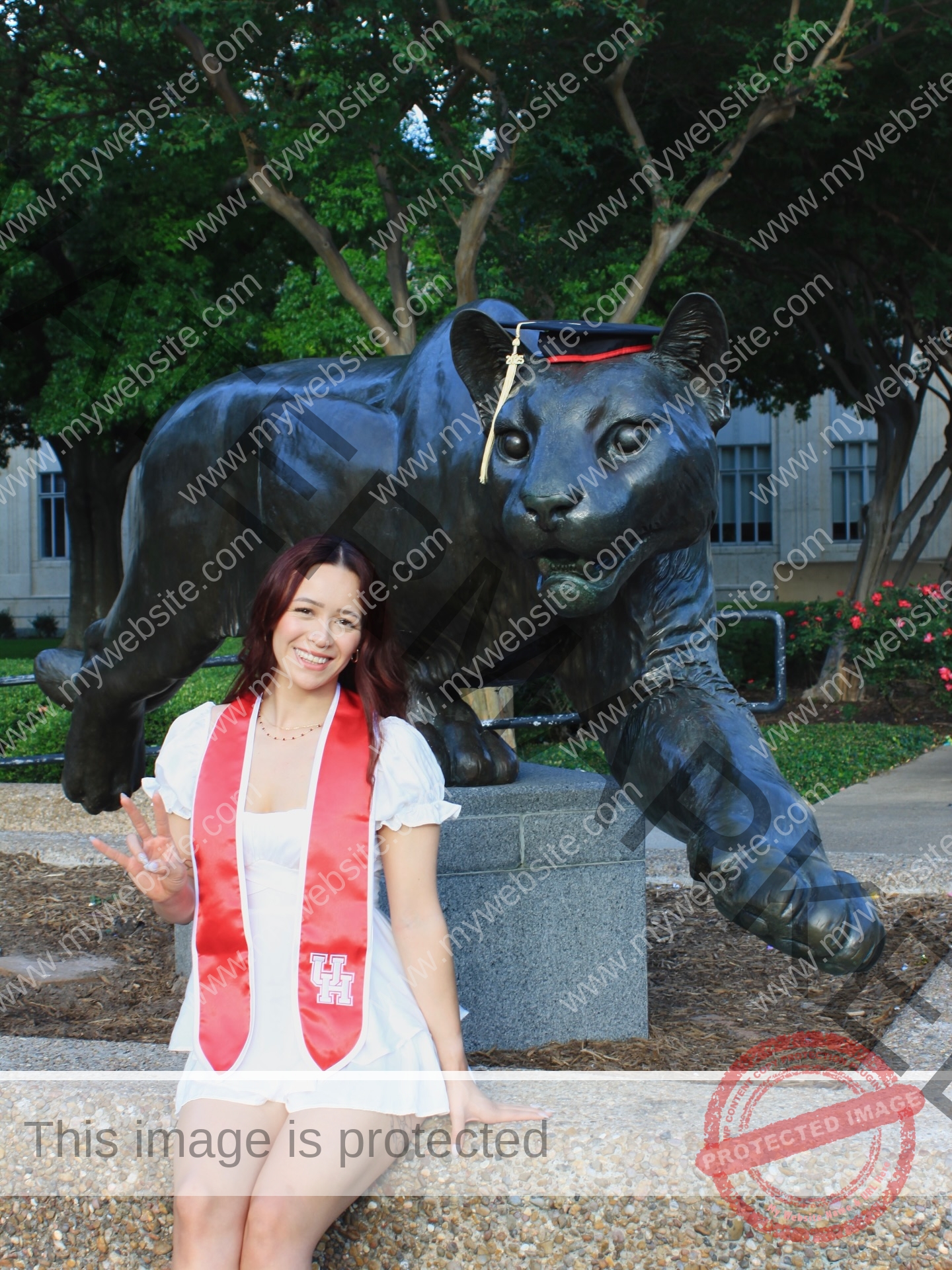 alondra-ortiz-costa-rica-alortizroman-691 Alondra Ortiz A smiling graduate, Alondra Ortiz—the swimming champion—poses in a white dress and red stole beside a panther statue.