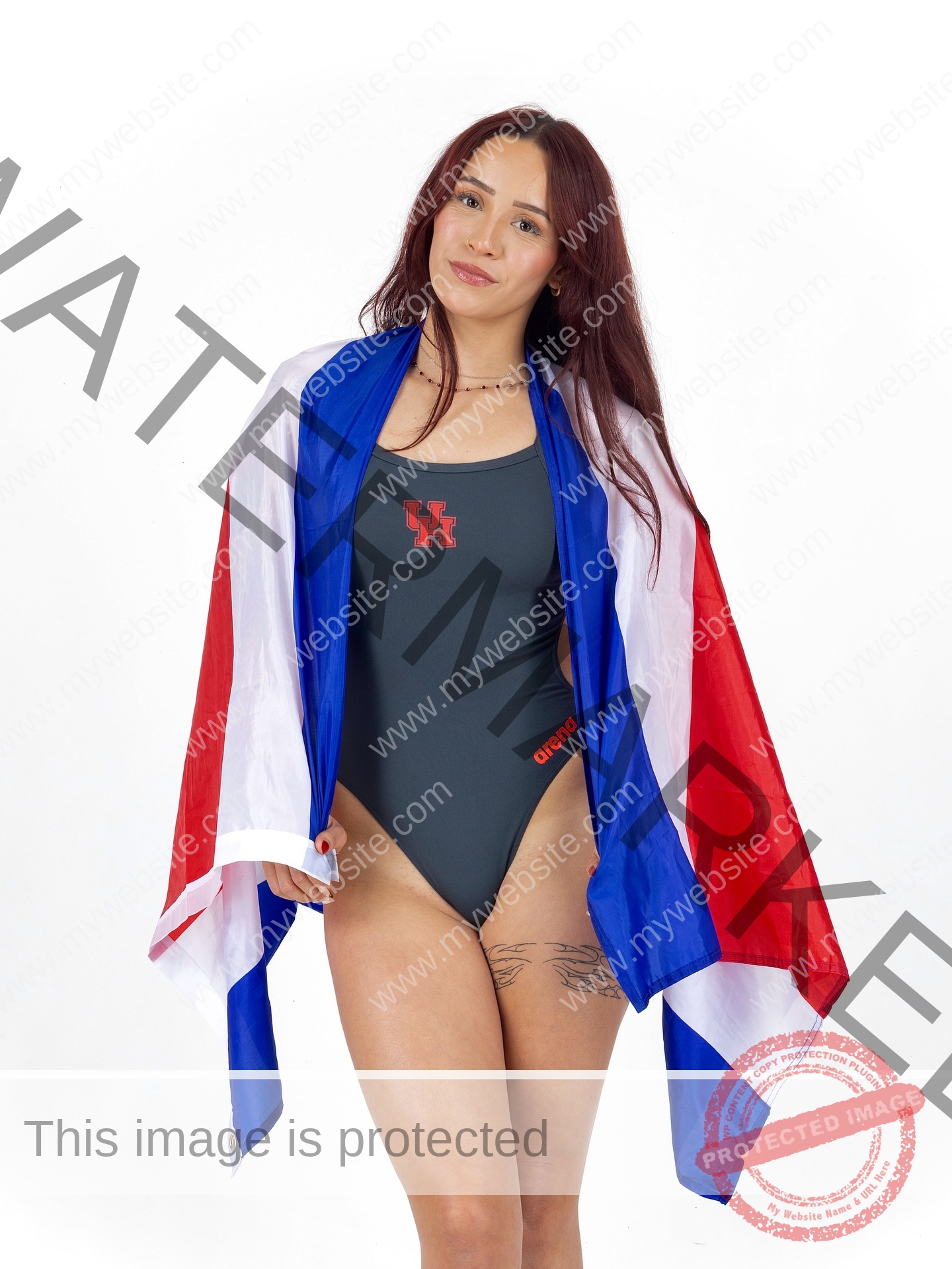 alondra-ortiz-costa-rica-alortizroman-726 Alondra Ortiz Swimming champion Alondra Ortiz, with long brown hair, wears a UH swimsuit and wraps in a red, white, and blue flag.