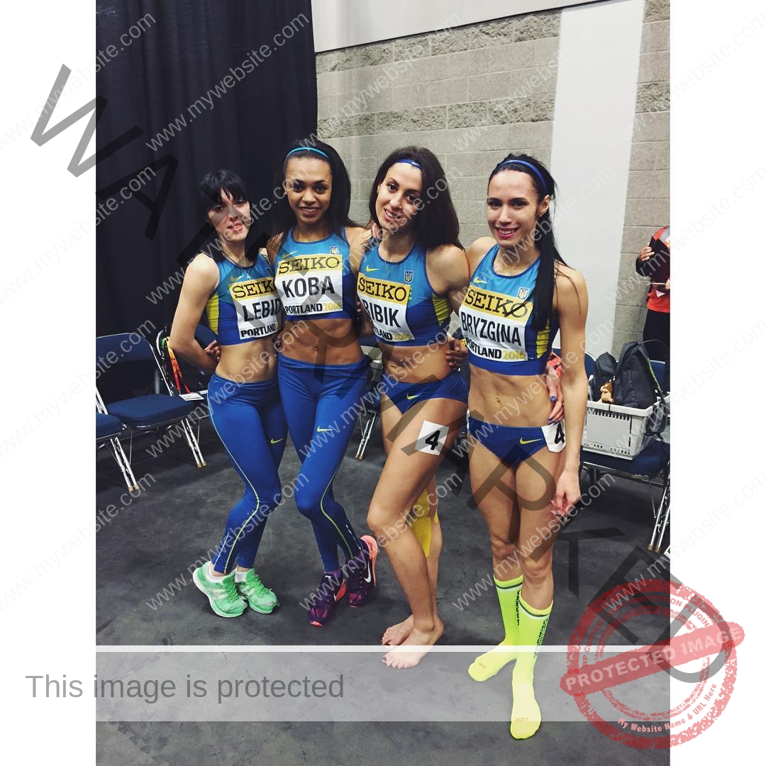 anastasia-bryzgina-ukraine-bryzgina_a-03707 Anastasia Bryzgina, track star from Ukraine, stands with three teammates in blue and yellow uniforms, smiling before a relay event.